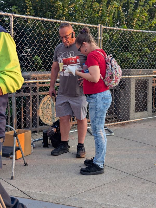 Mike Stockwell praying with a woman after preaching the gospel.